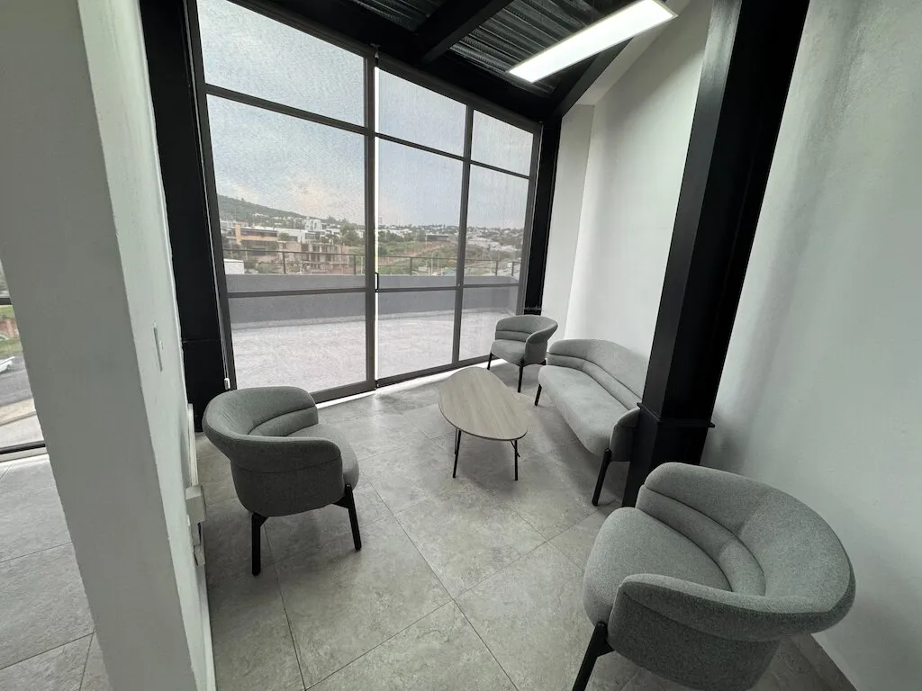 Sala de espera con sillones junto a ventanales