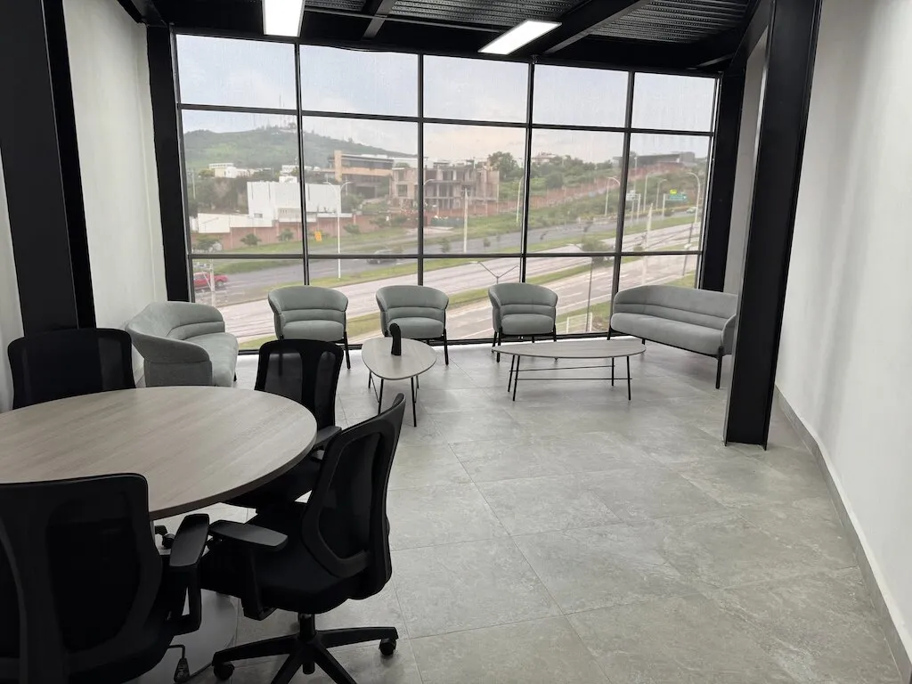Sala de estar con sillones y mesa redonda junto a ventanales